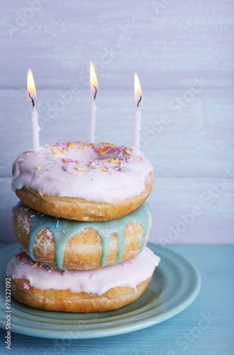 Delicious donuts with icing and birthday candles