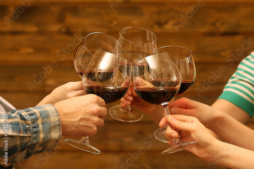 Clinking glasses of red wine in hands
