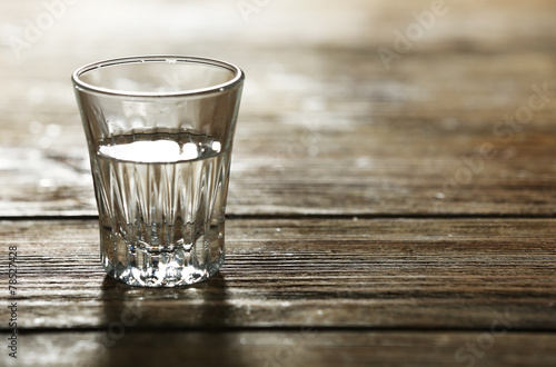 Glass of clean mineral water on rustic wooden planks background