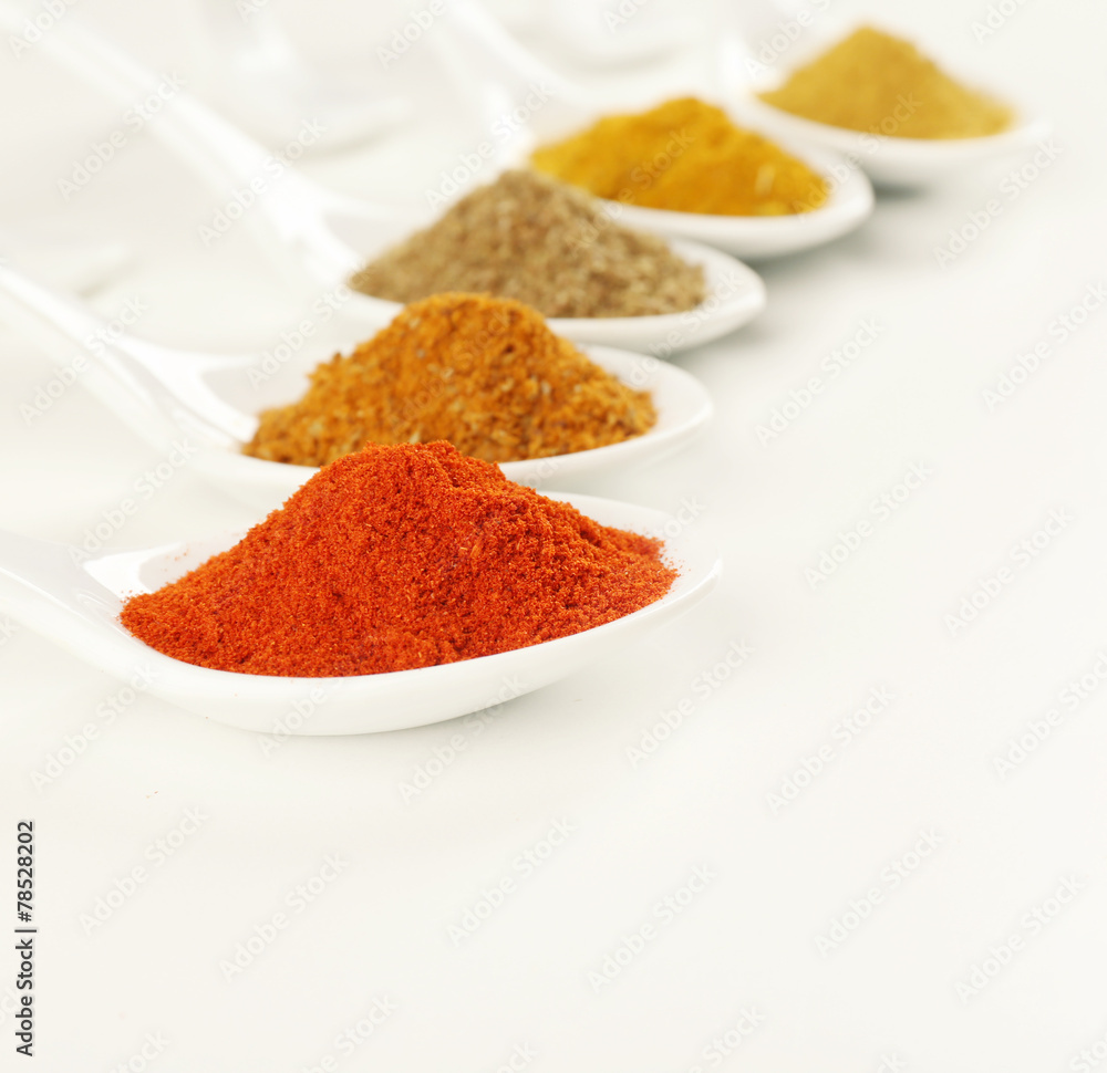 Different kinds of spices in ceramics spoons isolated on white Different kinds of spices in ceramics spoons isolated on white