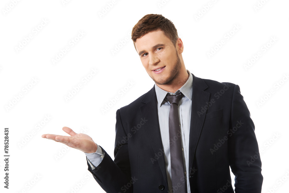 Handsome businessman holding copyspace on palm. Handsome businessman holding copyspace on palm.