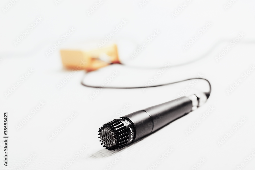 Lying microphone with yellow effect and cables in the back Lying microphone with yellow effect and cables in the back