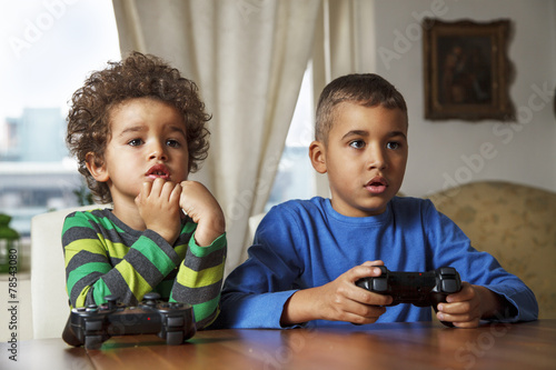Afro American boys playing video games at home.