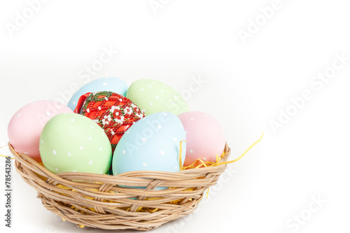 Easter basket with yellow grass filled with easter eggs