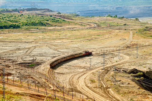 Open-pit mine, mining train carrying excavated materials.