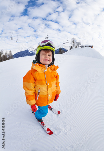 Cheerful boy wearing ski mask and helmet skiing
