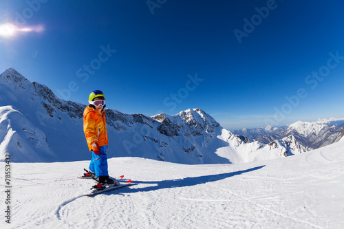 Boy skiing in sunny weather with mountain view