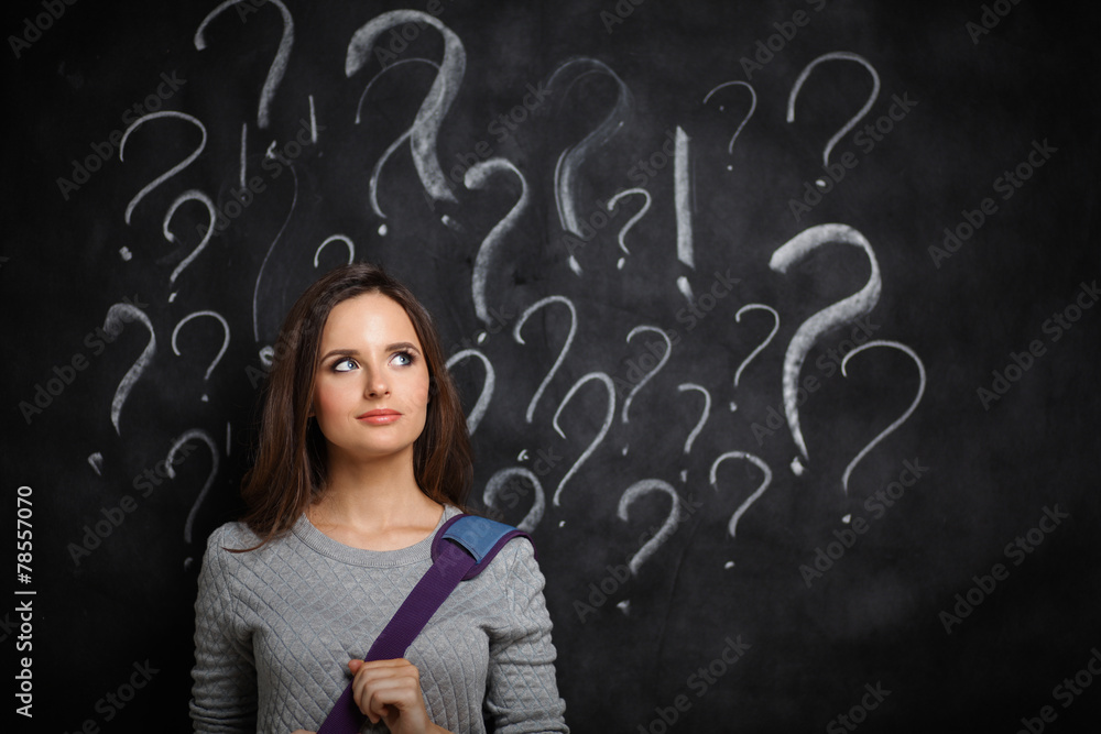 Young girl with question mark on a gray background Young girl with question mark on a gray background