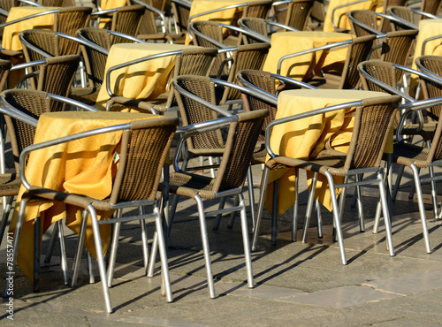 Street view of a coffee terrace with tables and chairs