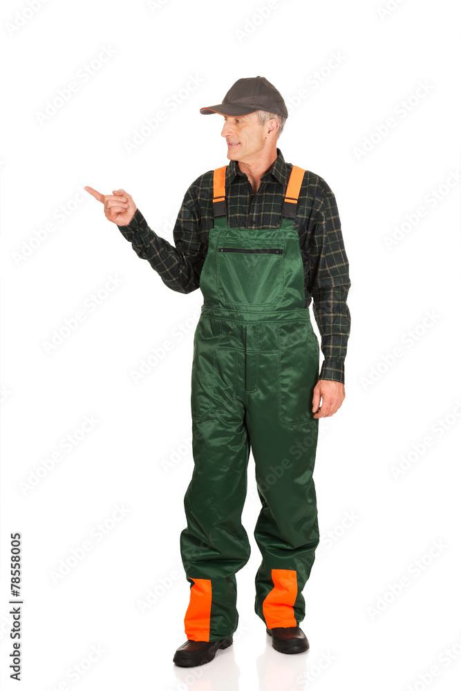 Mature gardener in uniform pointing to the left Stock Photo | Adobe Stock