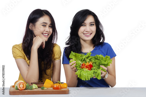 Friendly girls with vegetables salad