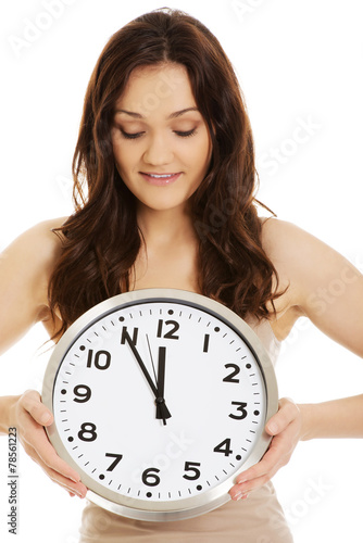 Smiling woman holding big clock.