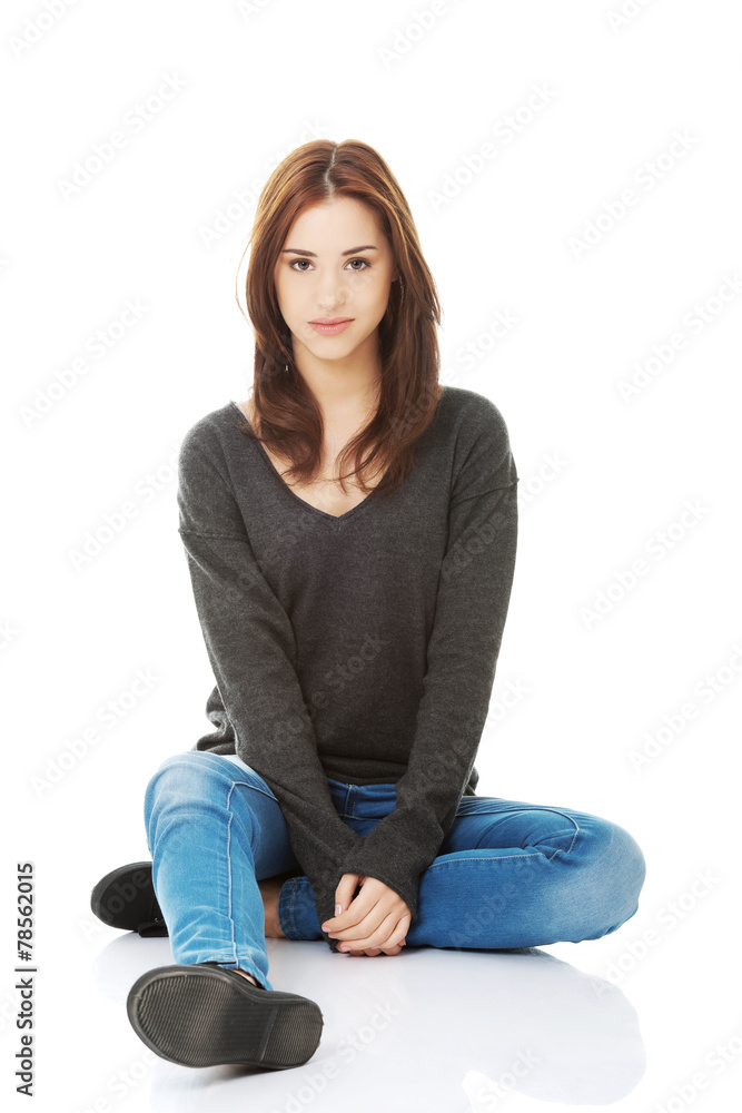 Casual young woman sitting on white floor Casual young woman sitting on white floor