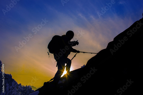 Silhouette of mountaineer and sunset.
