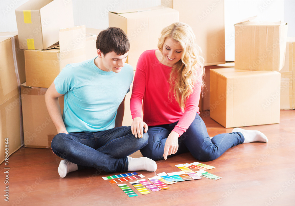 Young couple moving into a new home and choosing the right color Young couple moving into a new home and choosing the right color