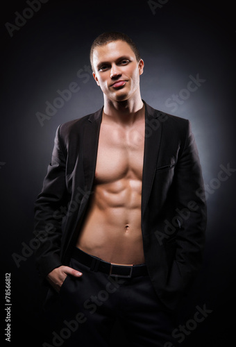 Strong, fit and sporty stripper man on a black background