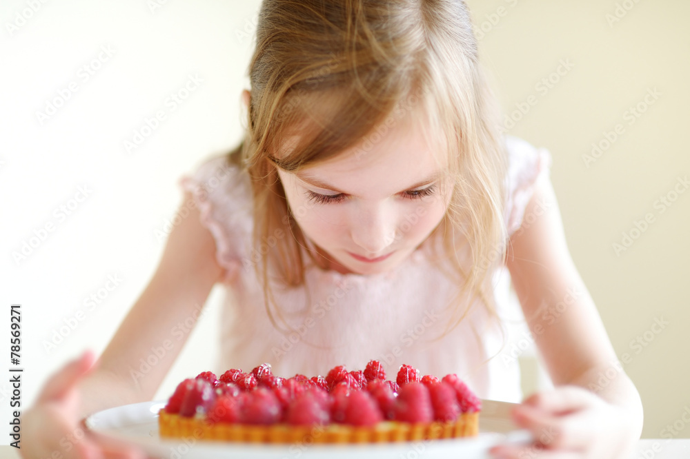 Adorable little girl and a raspberry cake