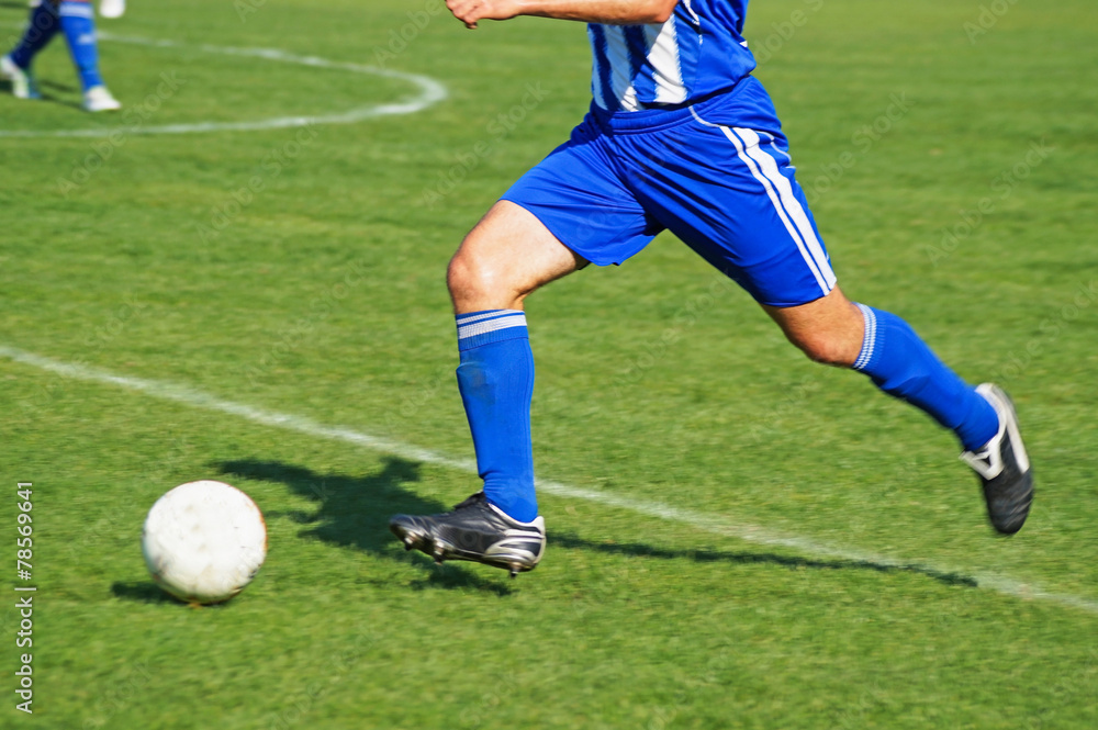 Soccer player is running with a ball