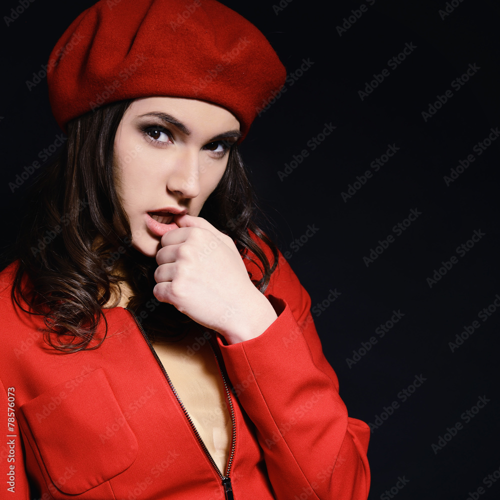 Stylish fashion girl in red suit and beret with, posing at studi Stock