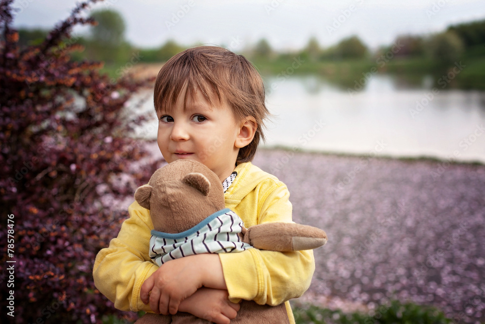 Adorable little boy, holding toy friend in a park Adorable little boy, holding toy friend in a park