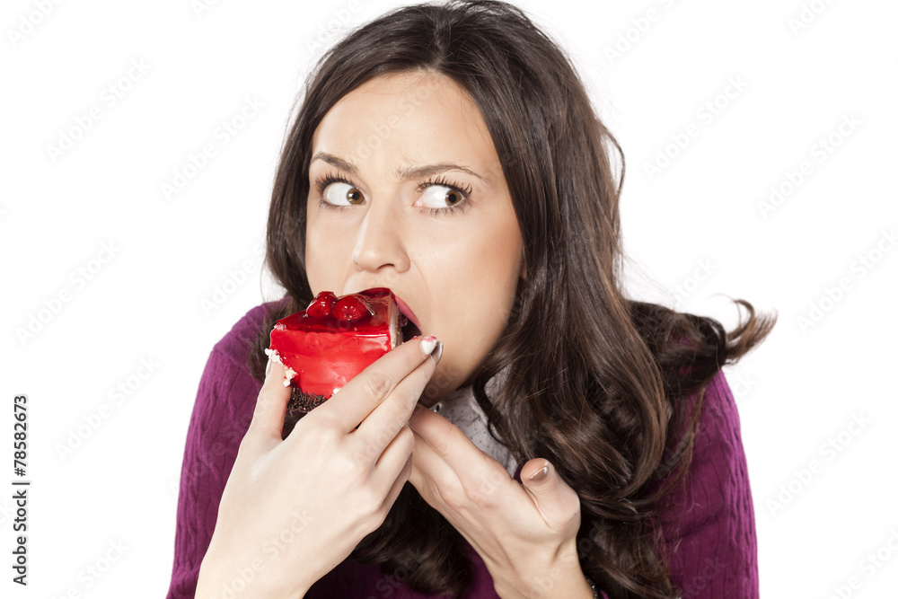 beautiful young woman eating cake secretly beautiful young woman eating cake secretly