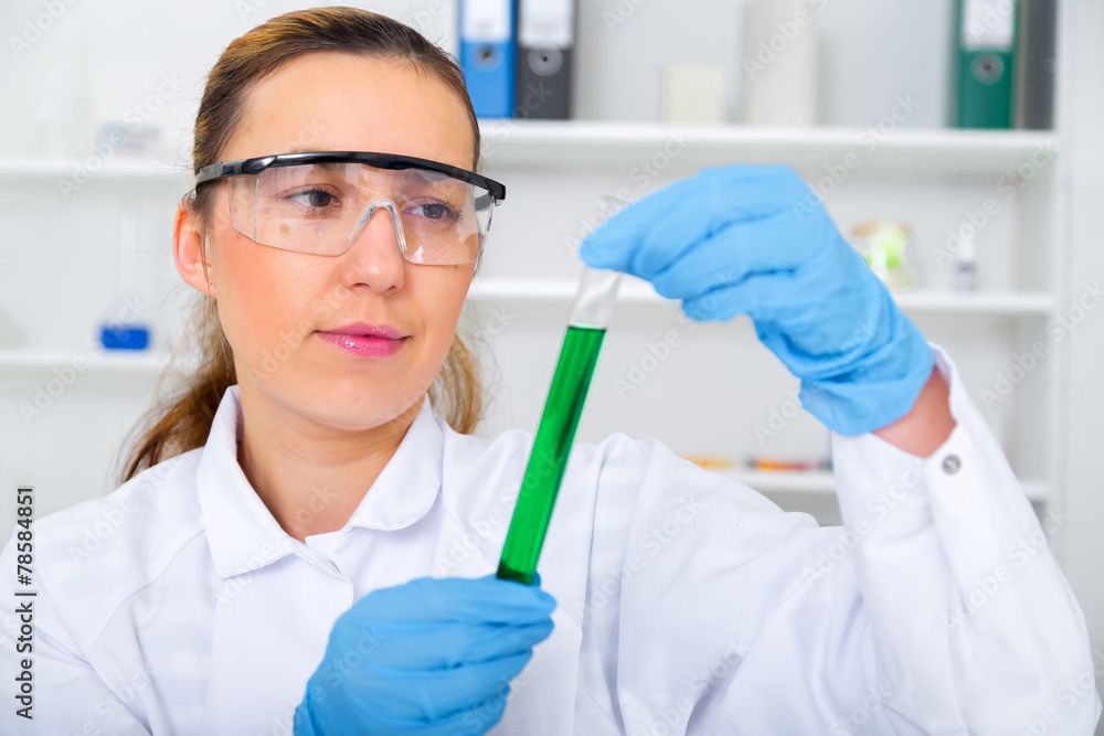 Chemist woman testing sample of liquid in laboratory Chemist woman testing sample of liquid in laboratory