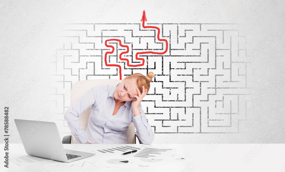 Business woman at desk with labyrinth and arrow Business woman at desk with labyrinth and arrow