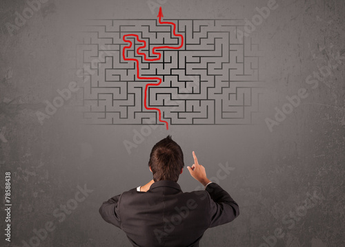 Business man looking at a maze and the way out