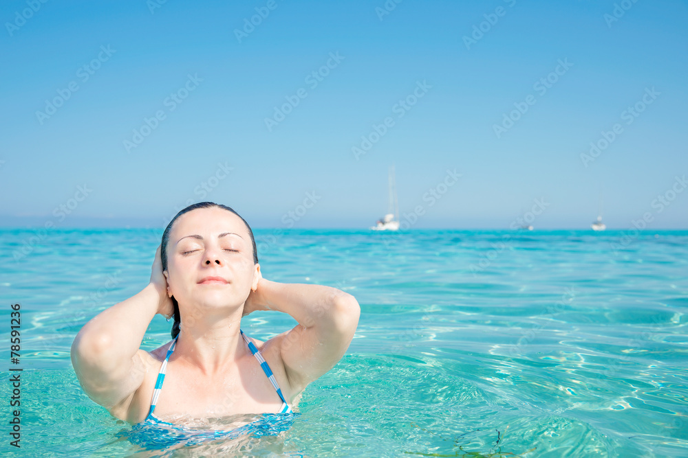 Young woman is relaxing in a heavenly sea Saleccia beach Corsica