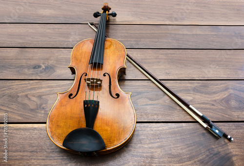 Foto Violin and a bow on a wooden background
