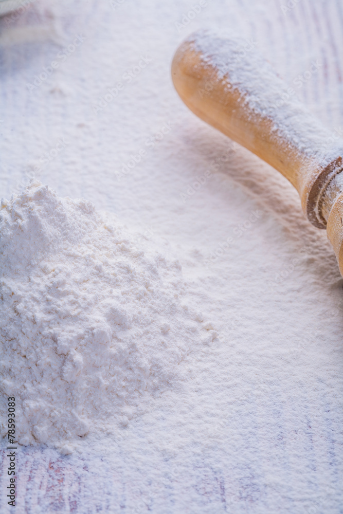 little pile of white natural flour and wooden rolling pin vertic little pile of white natural flour and wooden rolling pin vertic