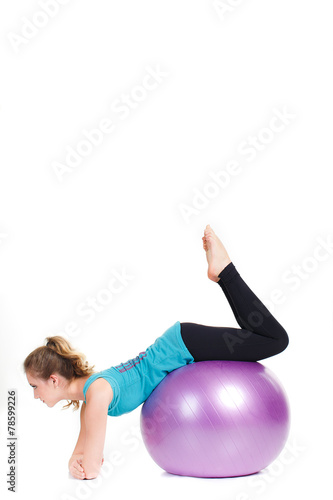 Girl-fitness instructor,shows exercises with a large ball.