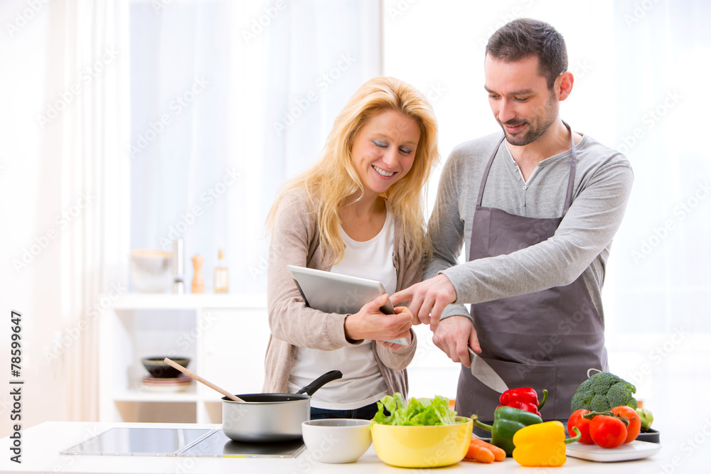 Young attractive couple reading recipe on a tablet Young attractive couple reading recipe on a tablet