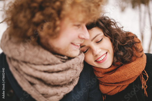 Young couple sitting in winter forest together