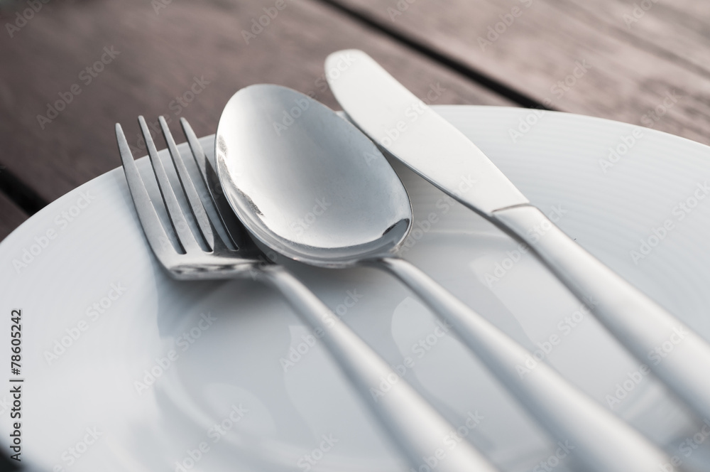 Fork spoon and knife on porcelain dish Fork spoon and knife on porcelain dish