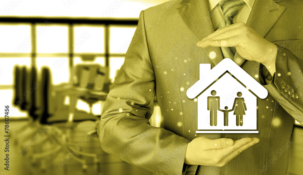 businessman protecting family in home with hands businessman protecting family in home with hands