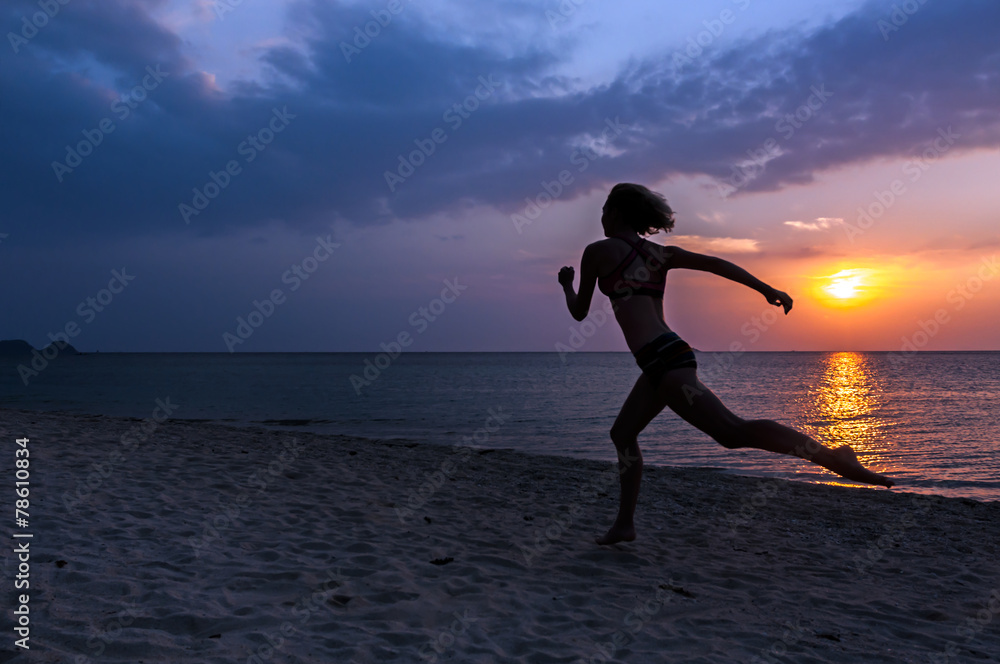 Sport young woman running on the beach at sunrise