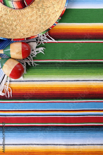 Mexican serape blanket background with sombrero and maracas for Mexico cinco de mayo festival fiesta photo vertical