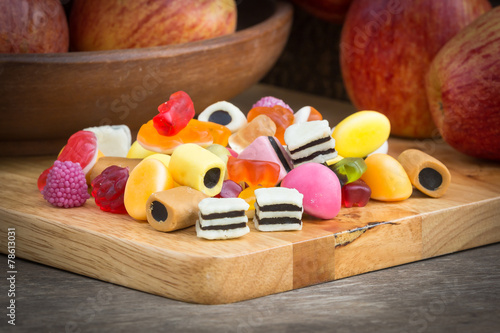 Mix jelly fruits on apple and wooden background