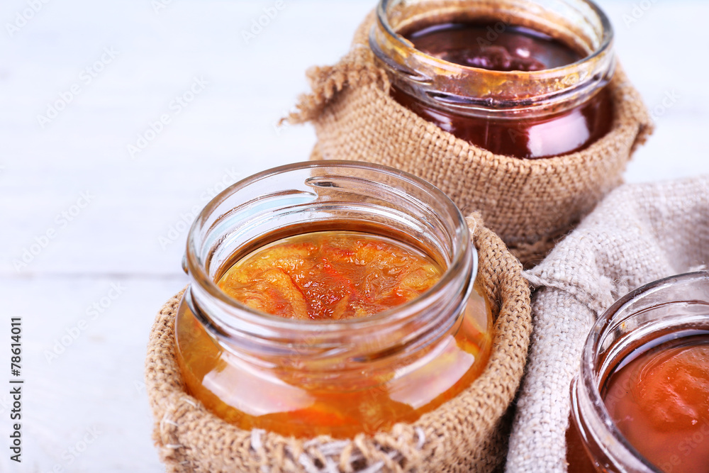 Homemade jars of fruits jam in burlap pouches Homemade jars of fruits jam in burlap pouches