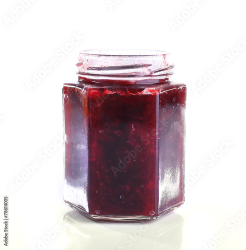 Homemade jar of plum jam isolated on white background