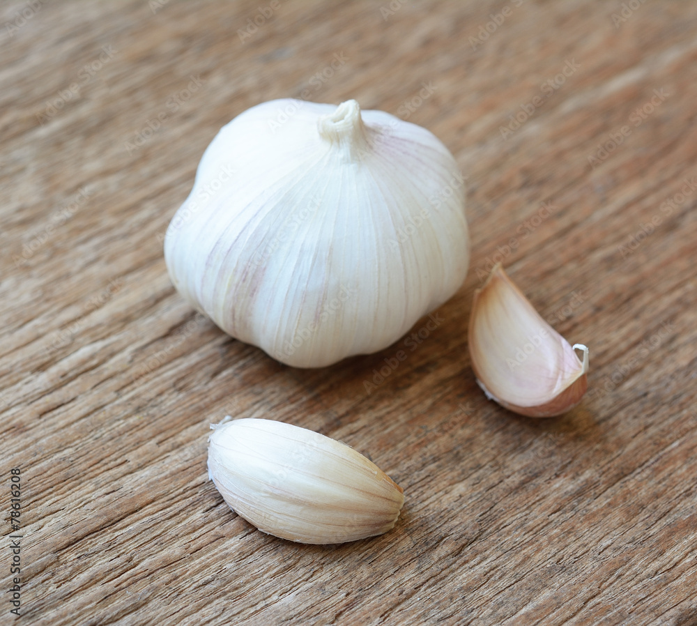 Organic garlic whole and cloves on the wooden background Organic garlic whole and cloves on the wooden background