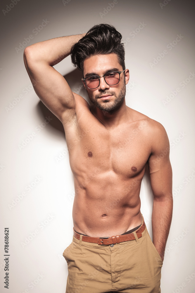 Fototapeta premium Hot sexy young man leaning on a white wal