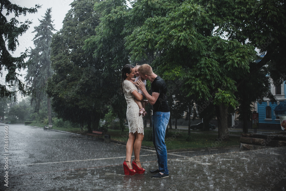 Obraz premium Happy family under the rain
