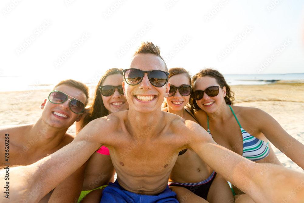 group of smiling friends making selfie on beach group of smiling friends making selfie on beach