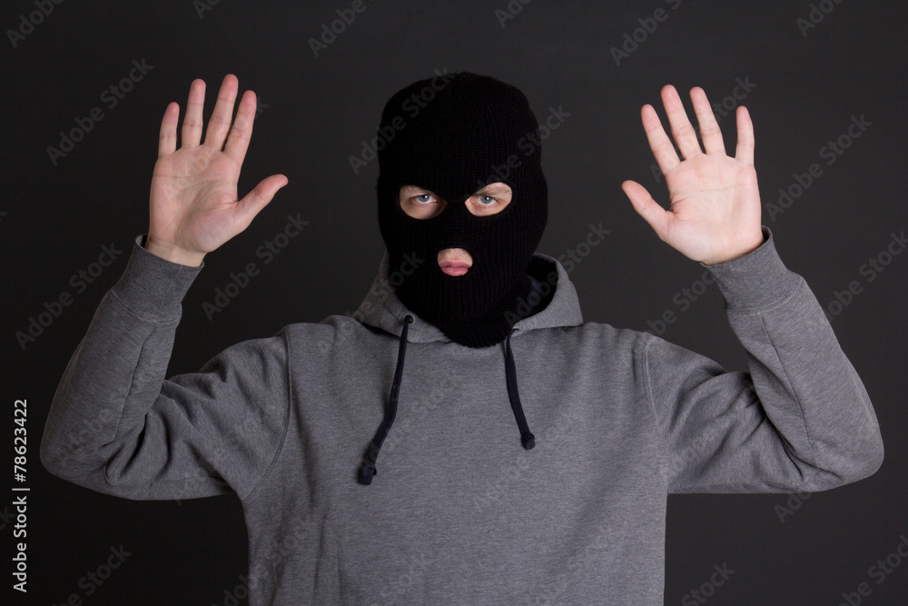 man in black mask holding hands up over grey man in black mask holding hands up over grey