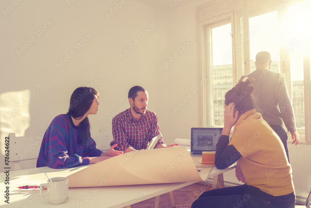 Obraz premium Young group of people/architects discussing business plans.
