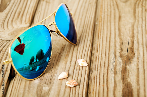 Tablou pe pânză blue mirrored sunglasses wiht reflection of martini glass on the