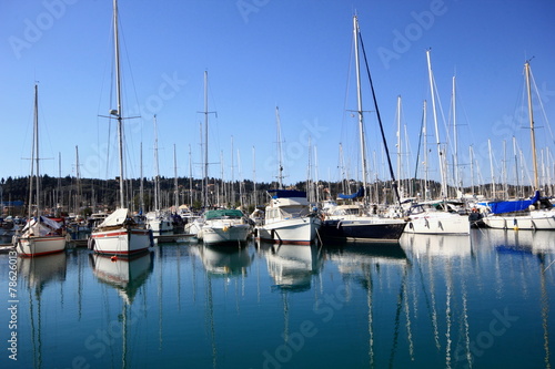 Yachts and sail boats reflected in a Marina harbour © William Richardson