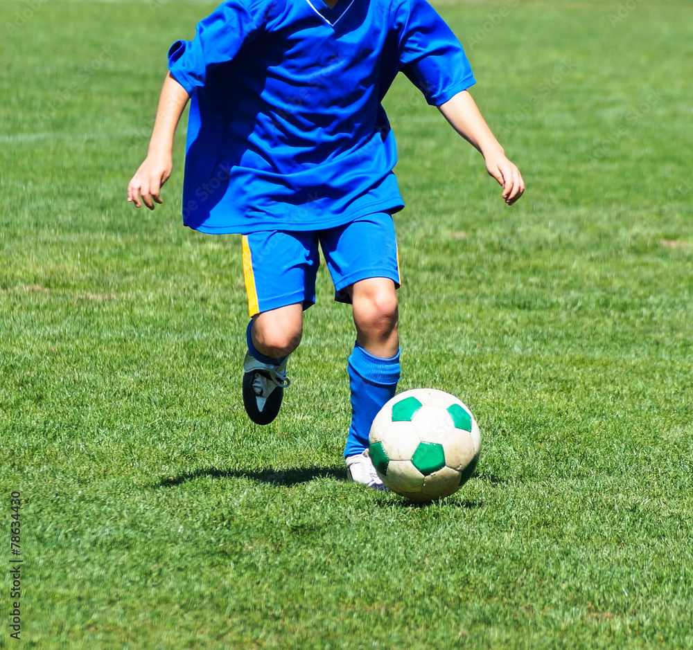 Young boy is running with a ball